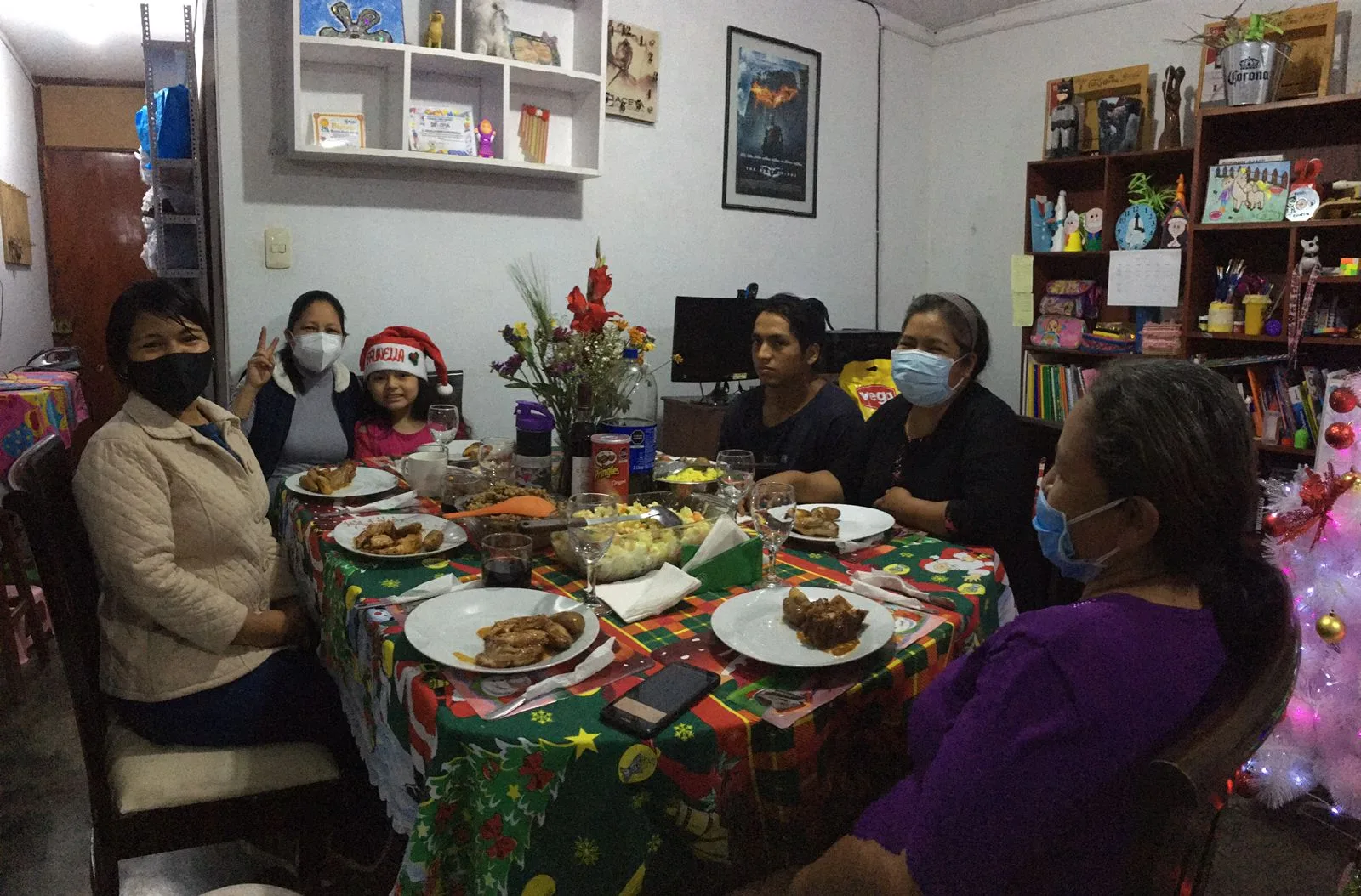Cena familiar multigeneracional con varias personas alrededor de una mesa servida.