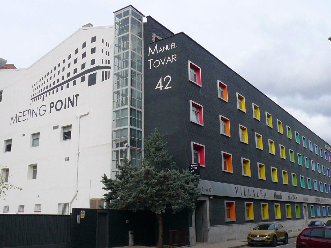 Interior de un espacio de coworking en Madrid con varias mesas compartidas y profesionales trabajando.