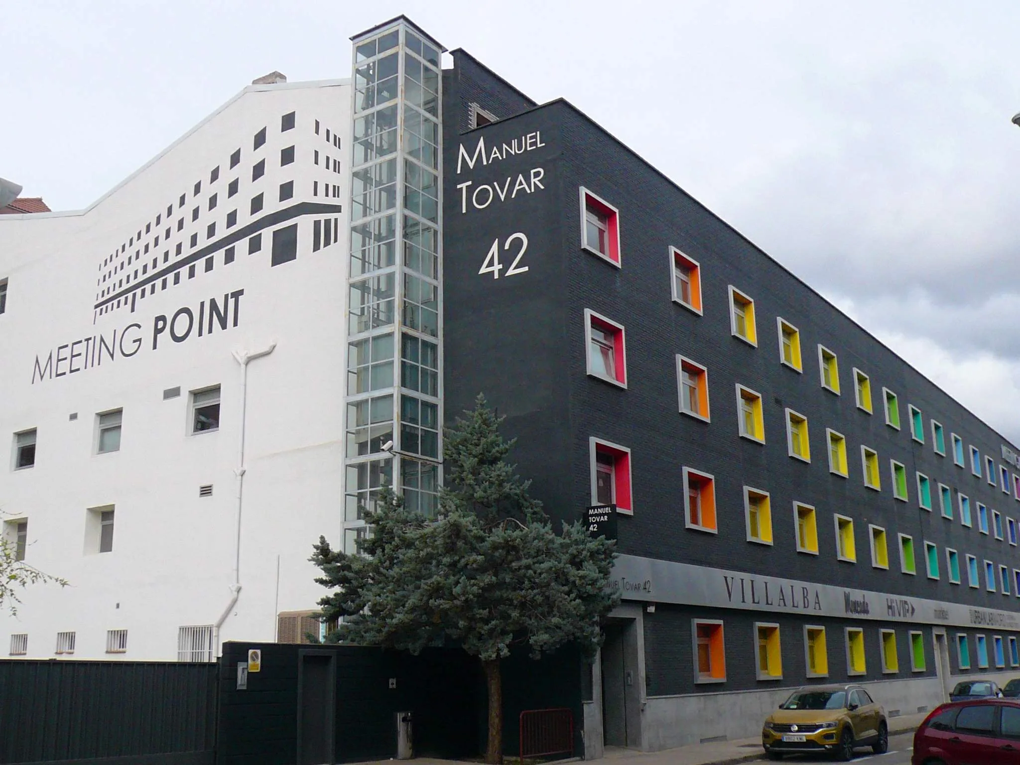 Interior de un espacio de coworking en Madrid con varias mesas compartidas y profesionales trabajando.