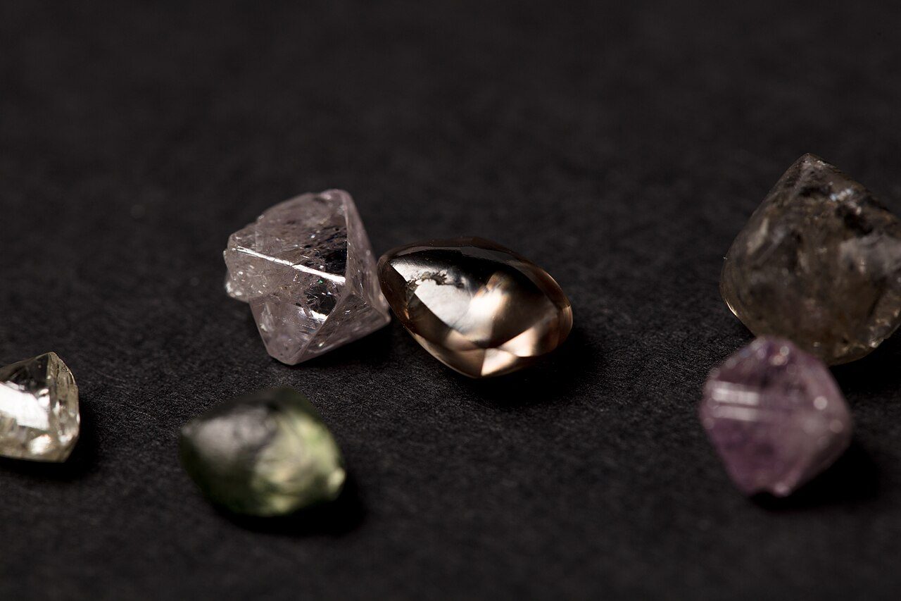 Cristales de diamante en bruto sobre roca, sin tallar, con sus caras naturales visibles.