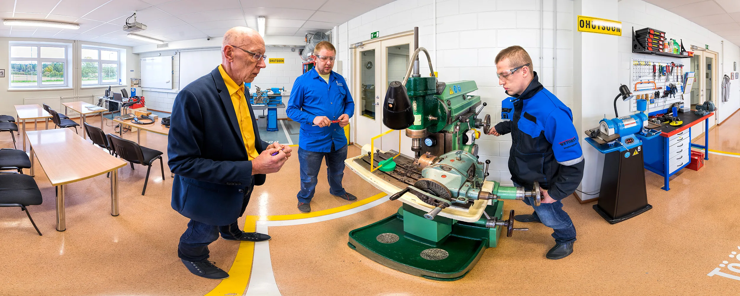 Interior de un taller de metalistería de un centro de formación profesional, con máquinas industriales y mesas de trabajo.
