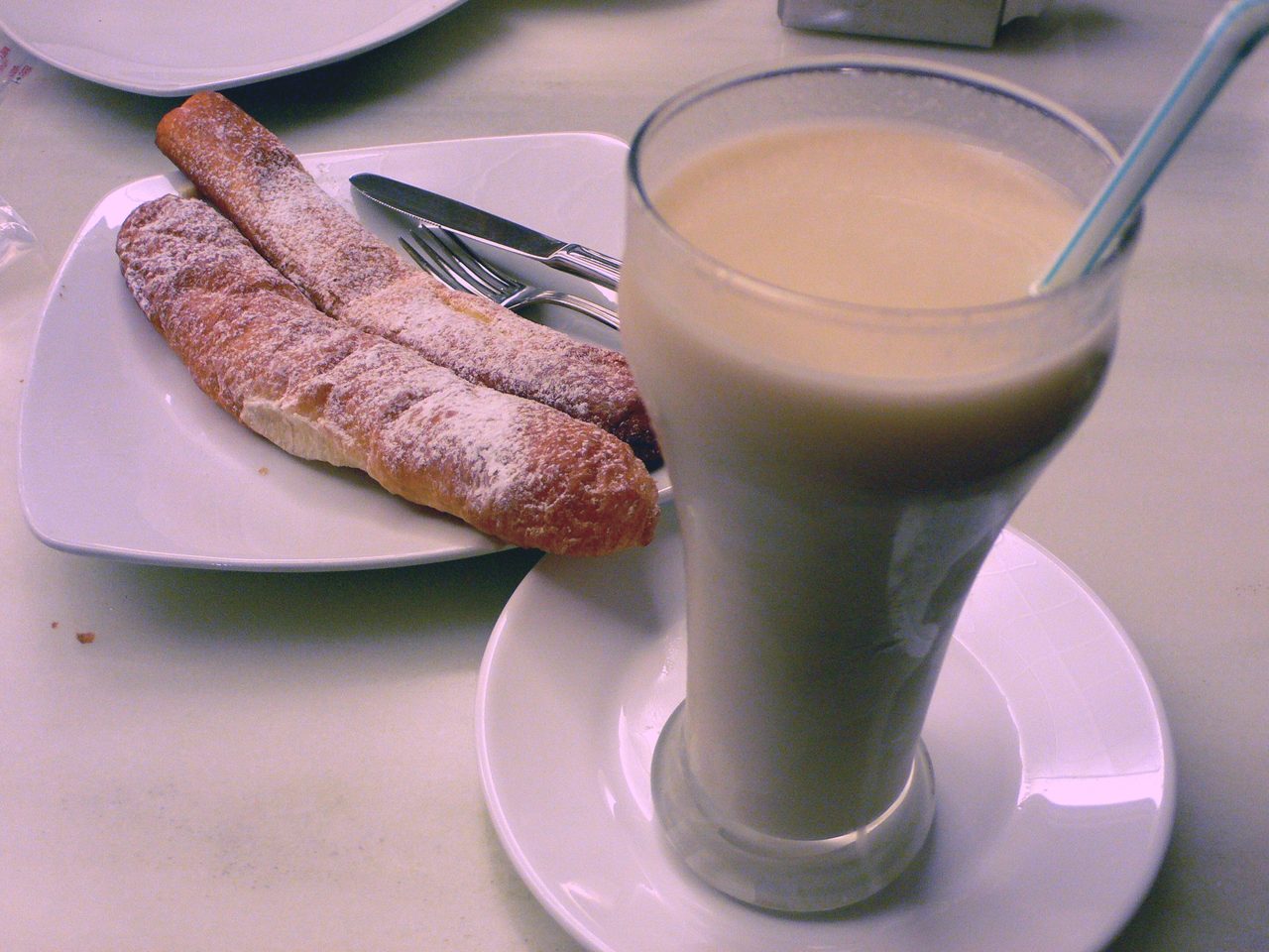 Mostrador de una horchatería tradicional en Valencia, con vasos de horchata y fartons servidos.