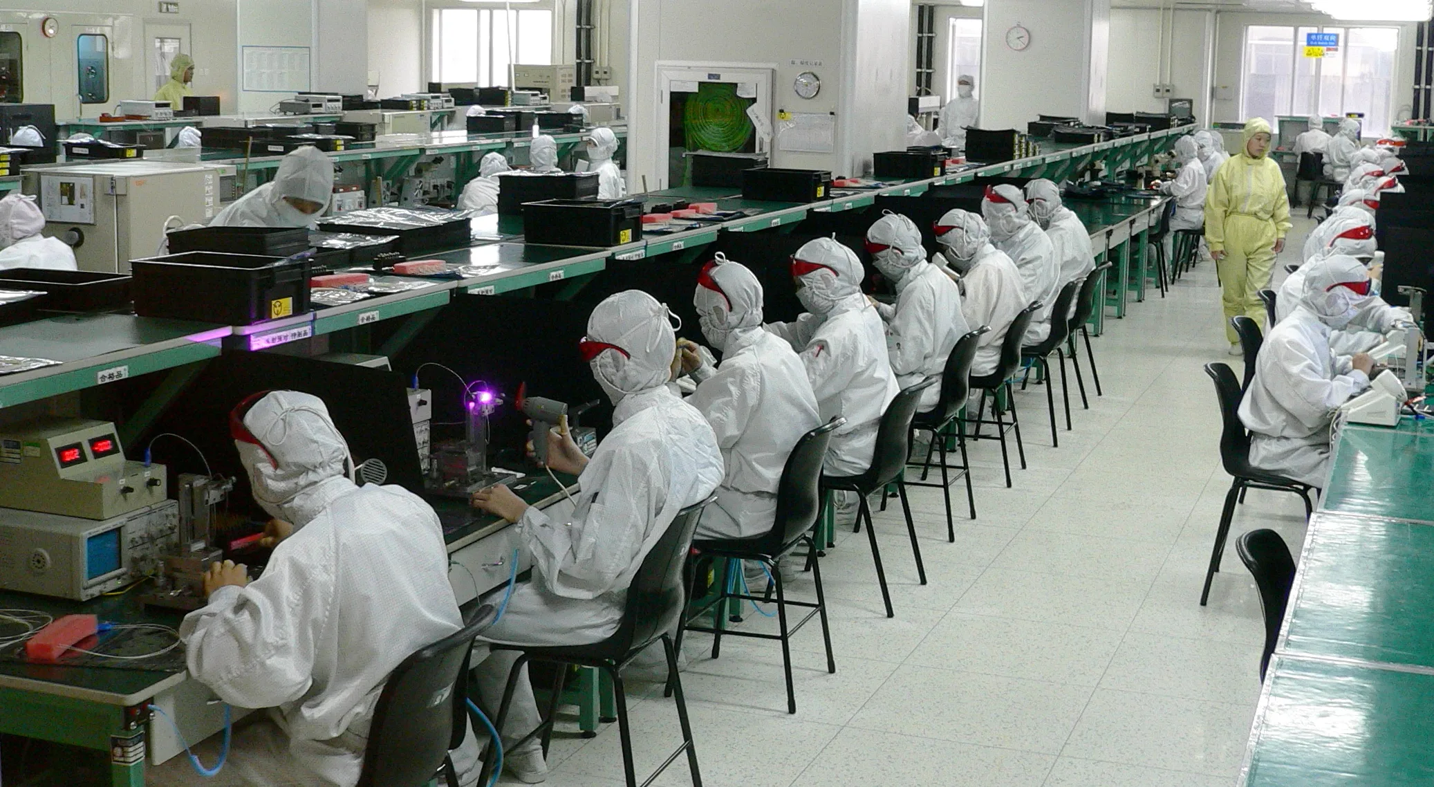 Operarios trabajando en una línea de montaje de una fábrica de electrónica.