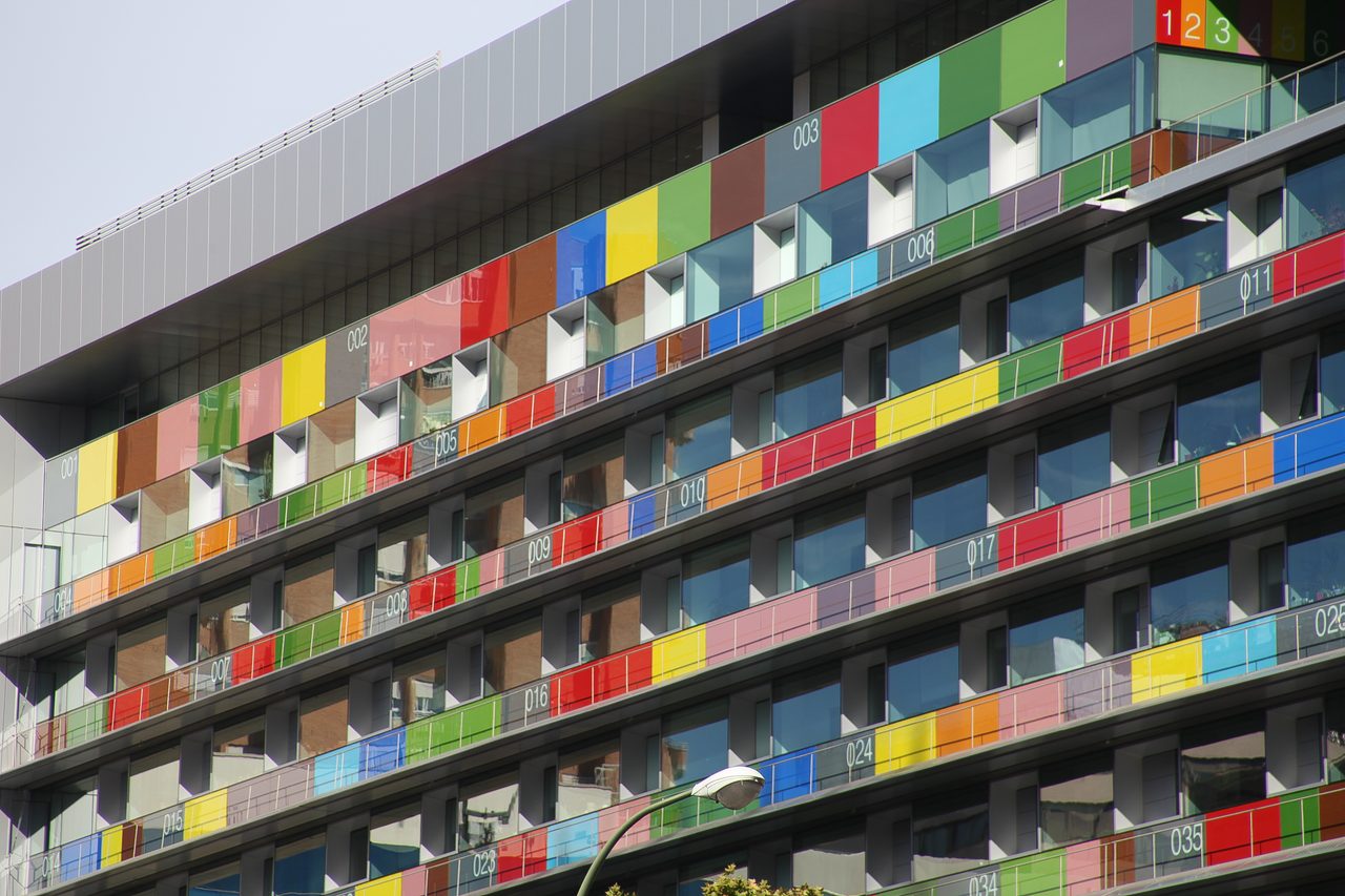 Fachada de la sede del Instituto Nacional de Estadística en el paseo de la Castellana de Madrid, con paneles de colores numerados.