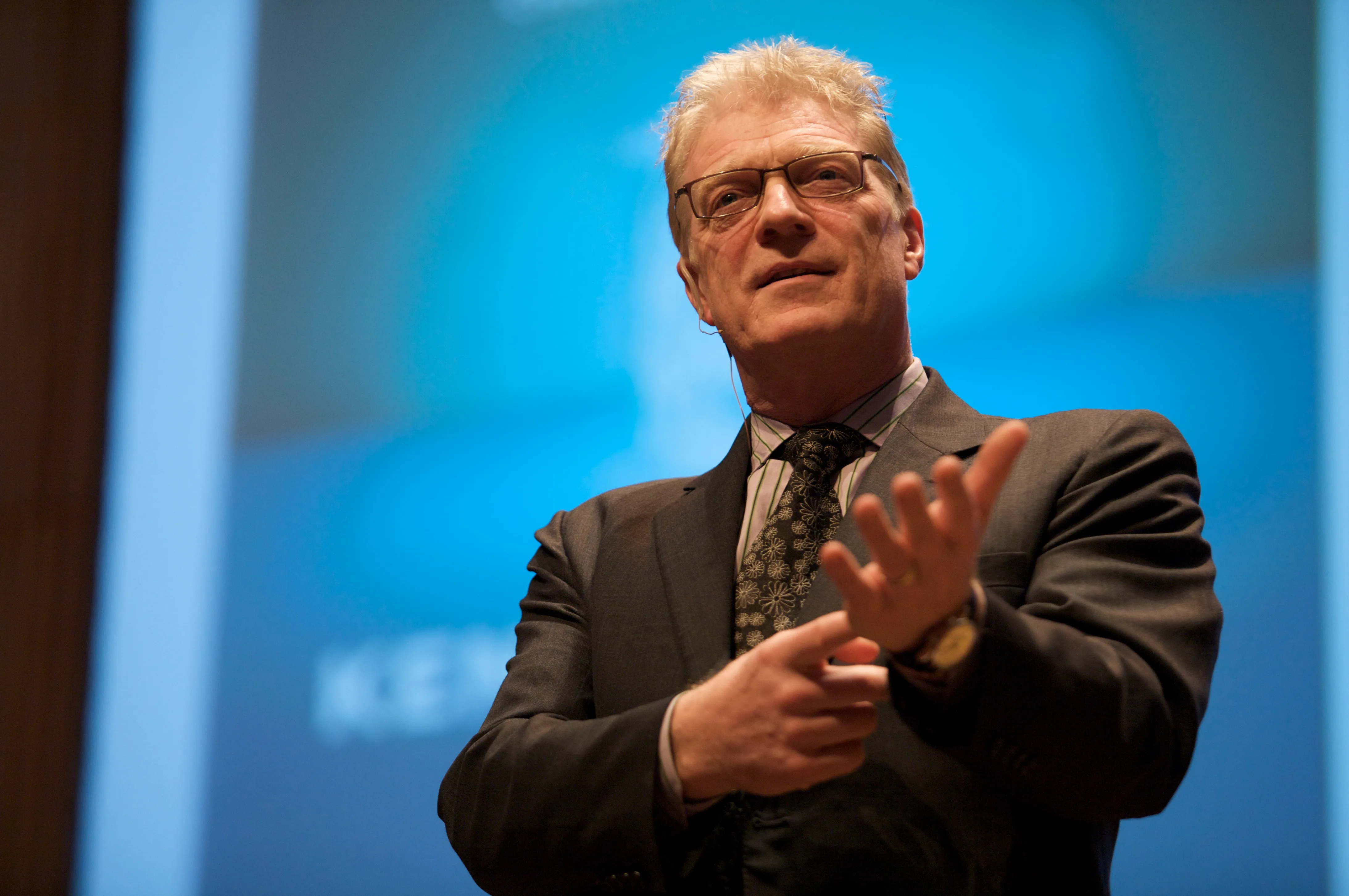 Retrato del educador Ken Robinson hablando en una conferencia