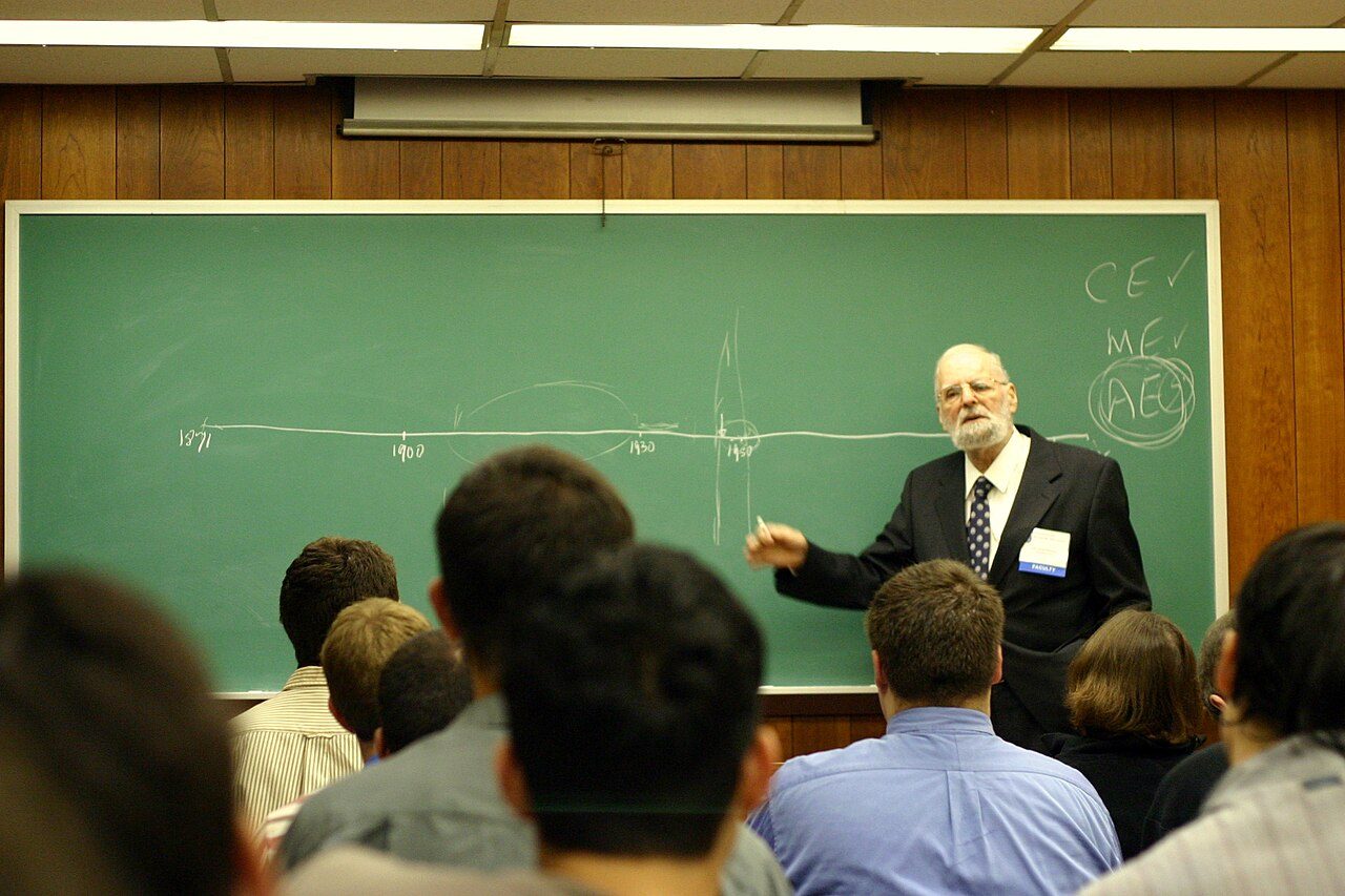 Israel Kirzner impartiendo una conferencia en la Foundation for Economic Education en 2006, gesticulando ante un atril.