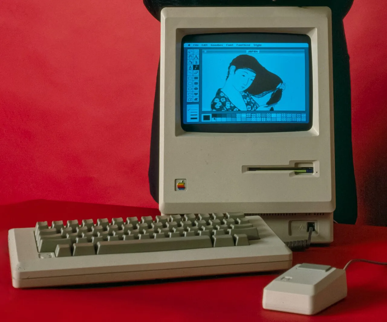 Ordenador Macintosh 128K original de 1984 fotografiado de frente sobre fondo neutro.