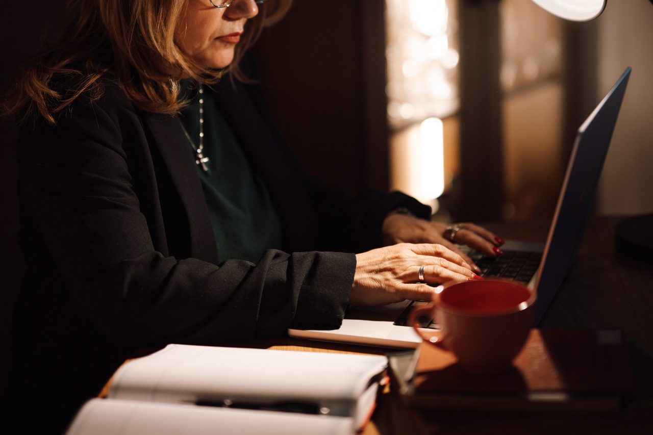 Persona trabajando con un portátil en una mesa de oficina luminosa