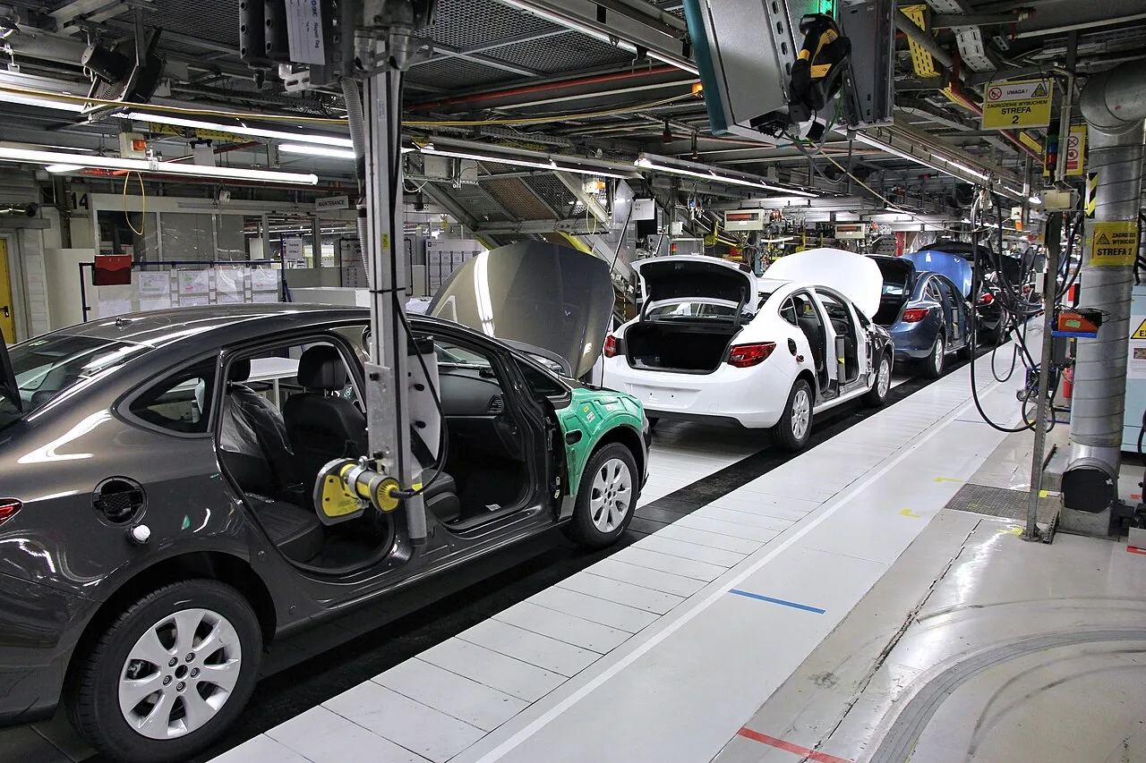 Cadena de montaje de la fábrica Opel en Gliwice (Polonia): una secuencia de carrocerías del Opel Astra J avanza sobre una línea continua mientras los operarios montan componentes a lo largo del recorrido.