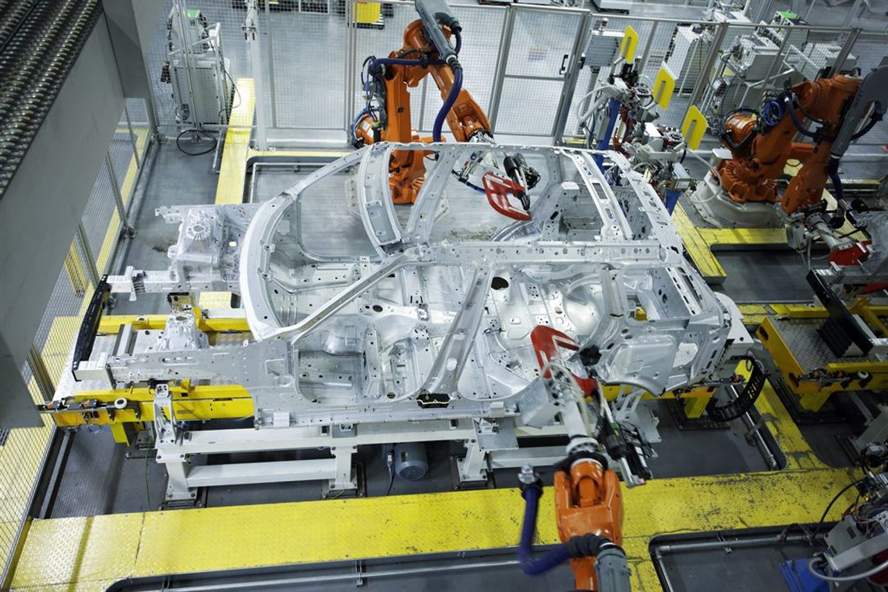 Brazos robóticos sueldan la carrocería de un automóvil en una línea de montaje