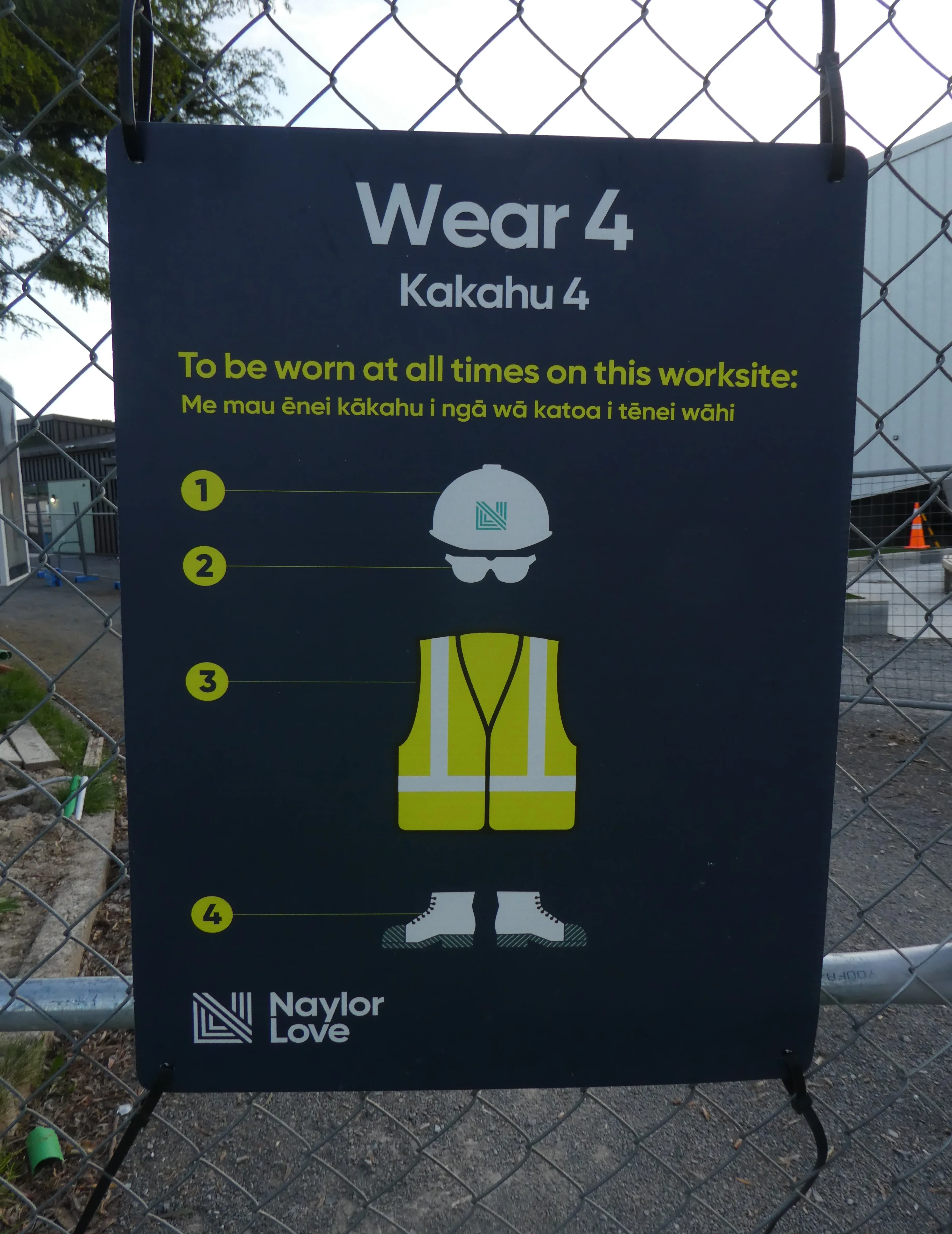 Señal de seguridad con pictogramas de advertencia y obligación en una zona de trabajo.