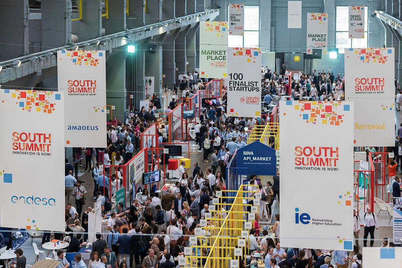 Zona del marketplace de South Summit 2019 en La Nave, Madrid, con stands de startups y asistentes entre los expositores.