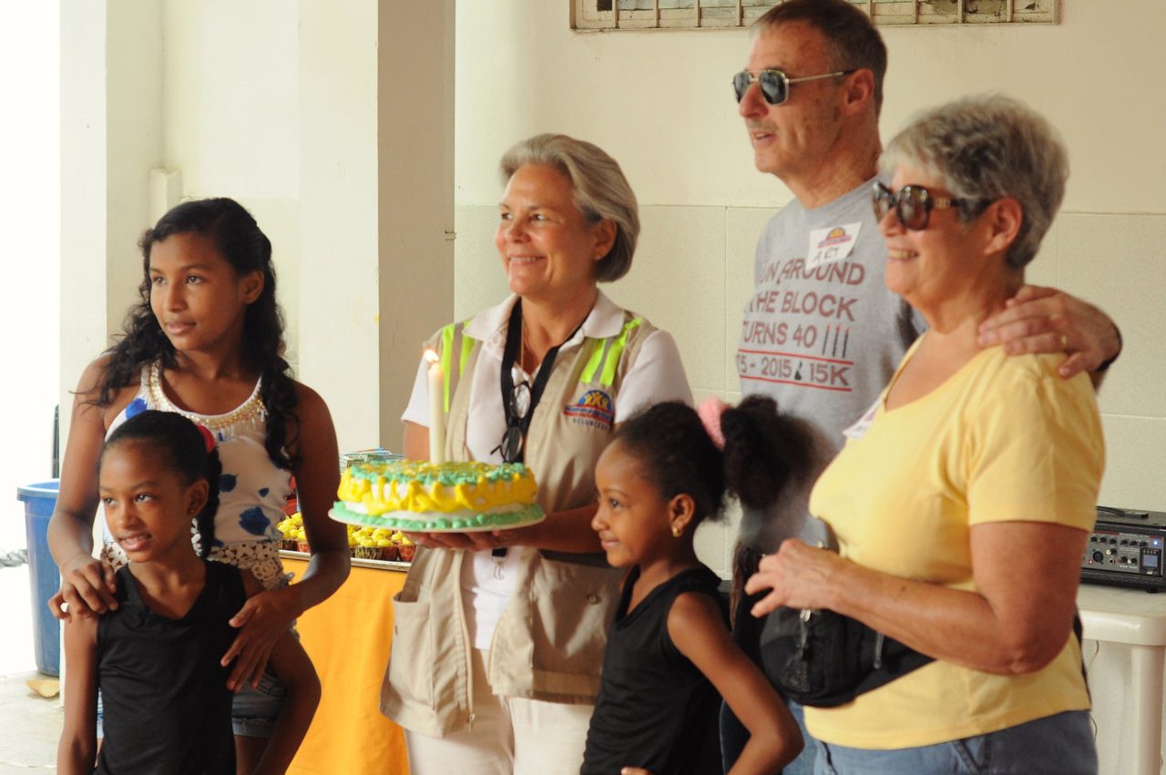Grupo de personas colaborando con vecinos en un proyecto comunitario al aire libre