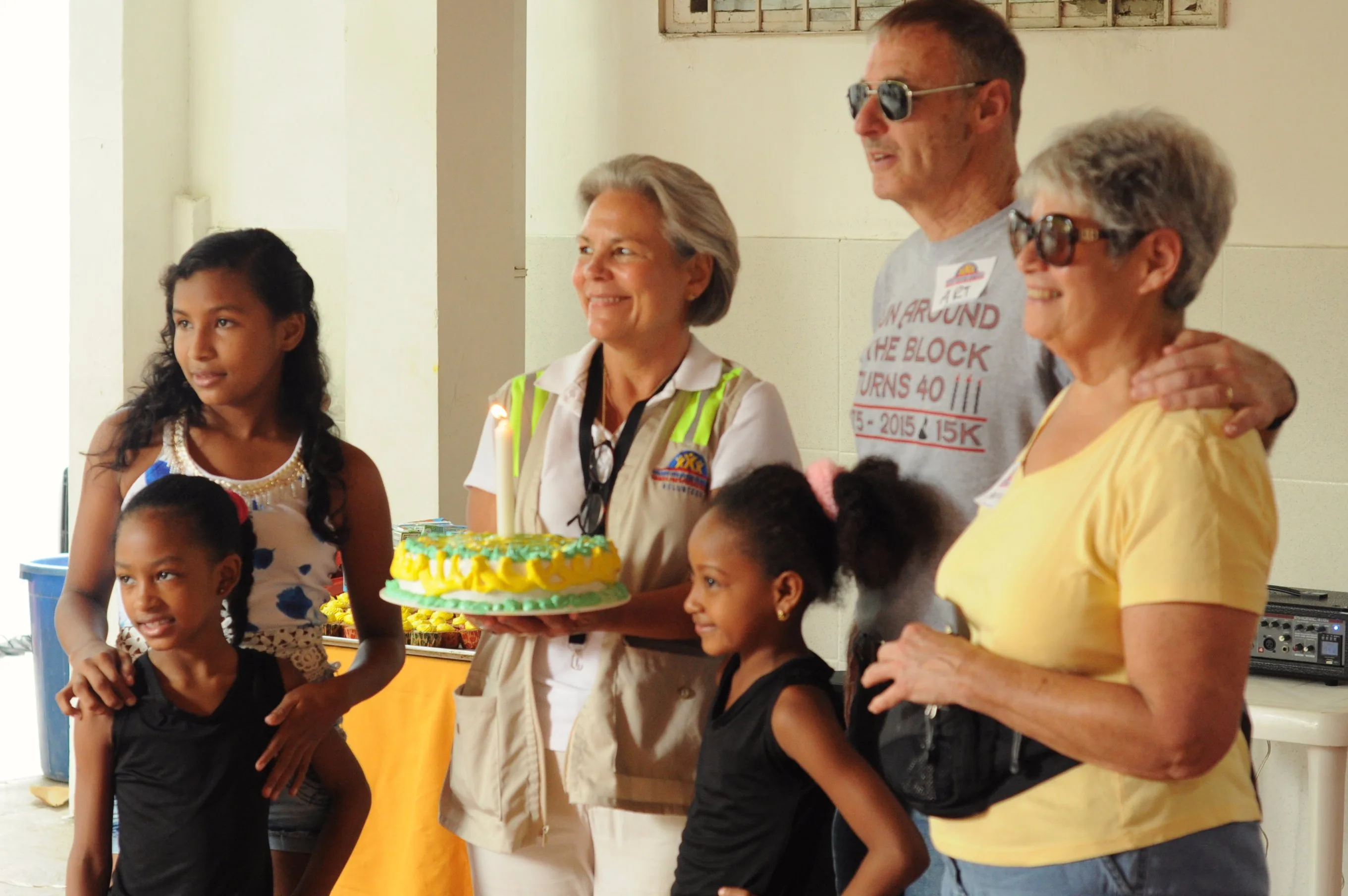 Grupo de personas colaborando con vecinos en un proyecto comunitario al aire libre.